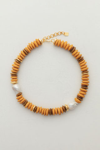 Candy Necklace Mustard, crafted with recycled glass beads, coconut and bone, gold-plated accents and two large baroque pearls.